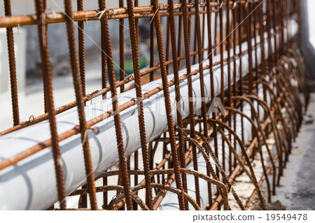 Closeup PVC pipes lined within rebar divider 19549478