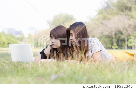 Young pretty woman with laptop lying 19551346