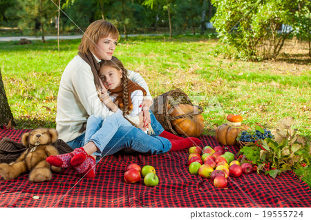 Happy mother with little daughter in autumn park Happy mother with little daughter in autumn park 19555724
