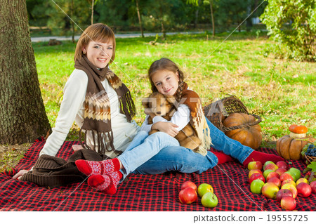 Happy mother with little daughter in autumn park Happy mother with little daughter in autumn park 19555725