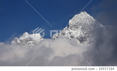 Peak of Mt Thamserku surrounded by clouds Peak of Mt Thamserku surrounded by clouds 19557184