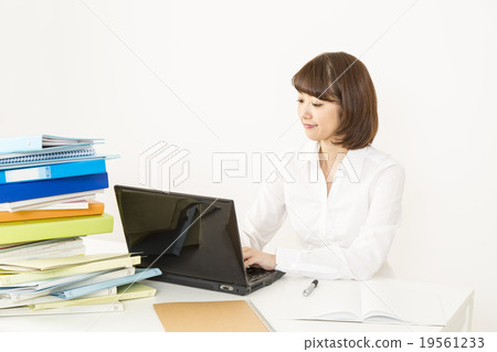 A woman doing office work before a lot of documents A woman doing office work before a lot of documents 19561233