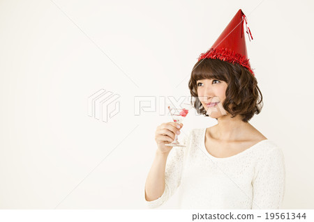 A woman wearing a triangular hat and having a cocktail 19561344