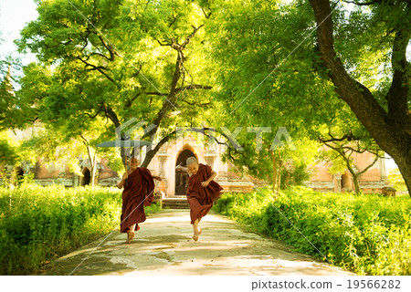 Young Buddhist novice monks running outside monastery Young Buddhist novice monks running outside monastery 19566282