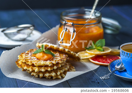 Wafers on baking paper with a jar of persimmon jam Wafers on baking paper with a jar of persimmon jam 19568606