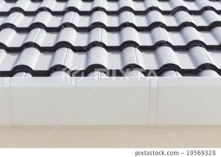 white gutter on the roof top of house 19569328