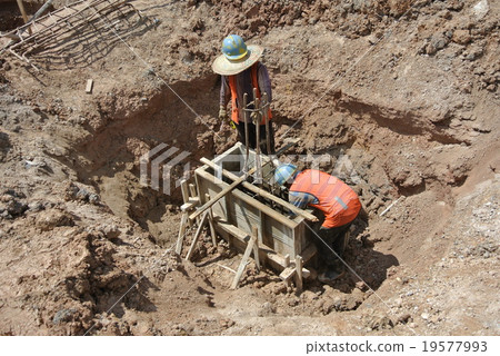 Construction workers installing pile cap form work Construction workers installing pile cap form work 19577993