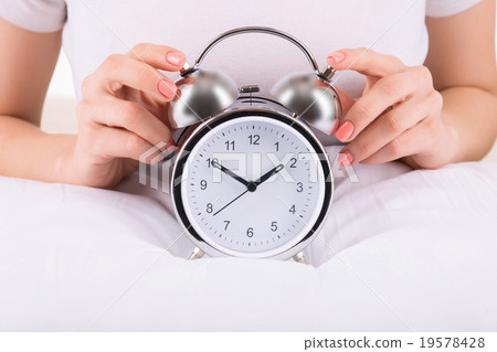Female hands and alarm clock 19578428