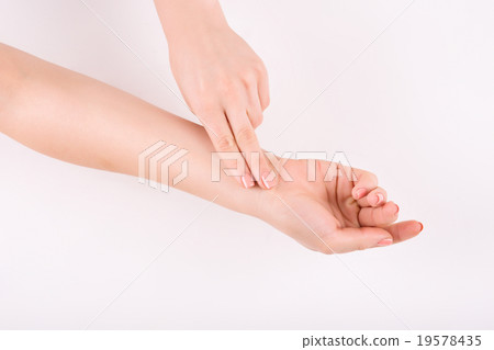 Female hands measuring pulse.  19578435