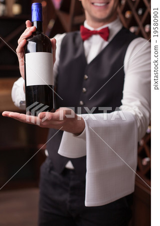 Cheerful young sommelier is showing perfect 19580901
