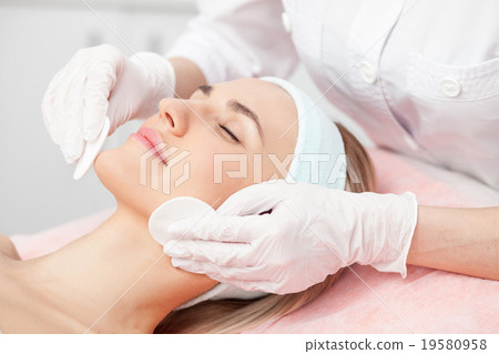 Professional young cosmetologist is curing female 19580958