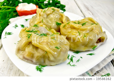 Manty with dill in dish on board 19586162