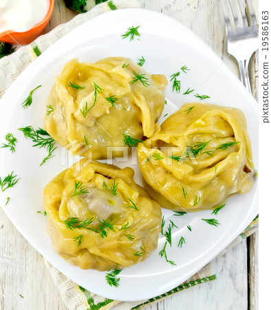 Manty with dill in dish on board top 19586163