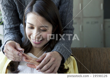 A woman receiving a ring 19598126