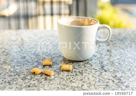 cup of coffee and and some biscuits on the table 19598717