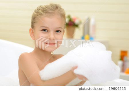 Pleasant little girl playing in bath tube Pleasant little girl playing in bath tube 19604213
