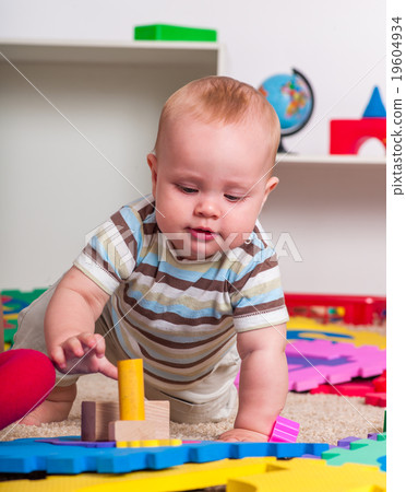 Kid baby boy plying with puzzle toy on floor. Kid baby boy plying with puzzle toy on floor. 19604934