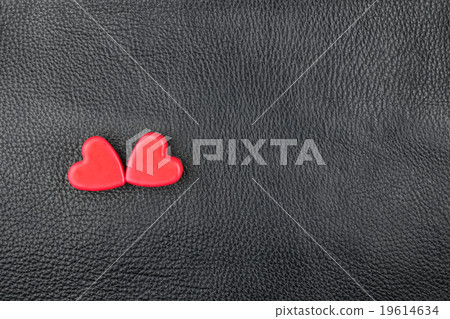 The concept of two lovers hearts lying on leather The concept of two lovers hearts lying on leather 19614634