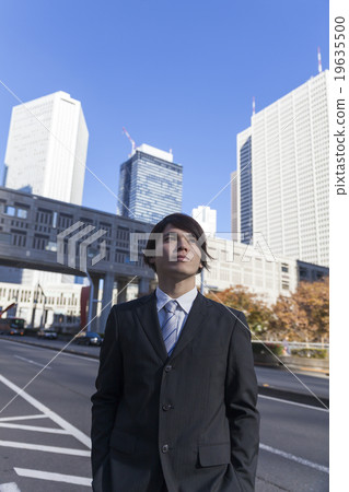 新宿摩天大樓看著天空在城市中的商人 19635500