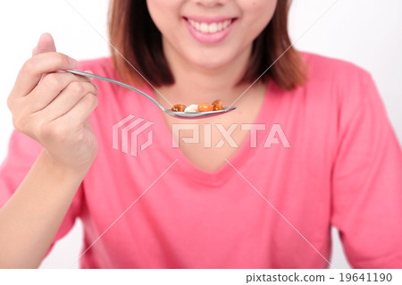 Young women eating medicine capsules on spoon. Young women eating medicine capsules on spoon. 19641190