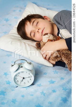 six years old child sleeping in bed with alarm 19644526