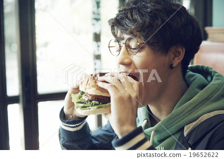 A man who is lunch at a cafe 19652622