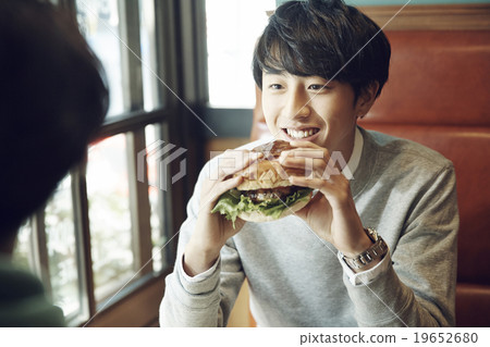 Men lunch with friends at a cafe 19652680