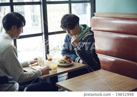 A man who is lunch at a cafe 19652998