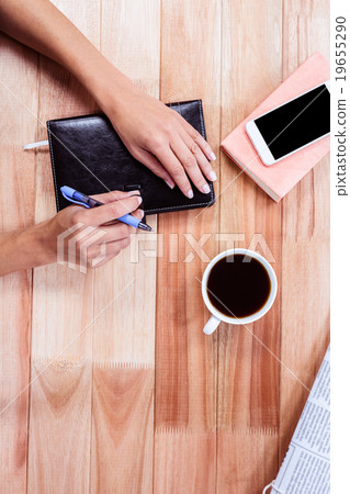 Overhead of feminine hands closing agenda Overhead of feminine hands closing agenda 19655290