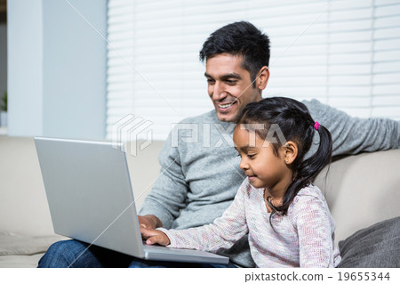 Happy mother and daughter reading a book on the bed 19655344