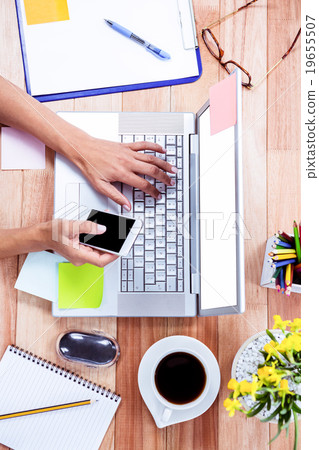 Overhead of feminine hands using laptop and smartphone Overhead of feminine hands using laptop and smartphone 19655507