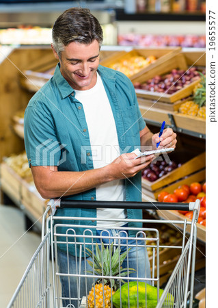 Smiling man looking at his list Smiling man looking at his list 19655577
