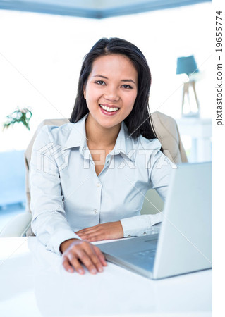 Smiling businesswoman at her desk Smiling businesswoman at her desk 19655774
