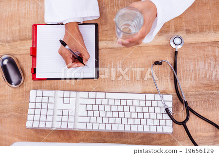 Doctor holding pen and glass of water Doctor holding pen and glass of water 19656129