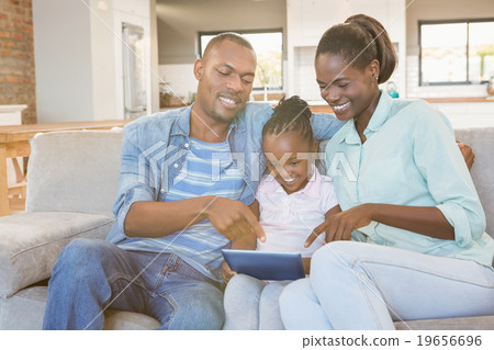 Parents watching daughter using tablet pc 19656696