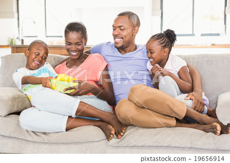 Happy young family giving a present to their son Happy young family giving a present to their son 19656914