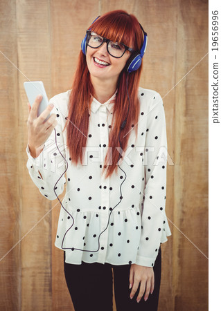 Attractive hipster woman listening to music with headphones 19656996
