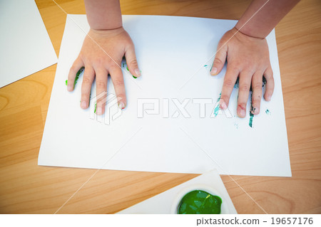 Boy pressing his paint covered hands Boy pressing his paint covered hands 19657176
