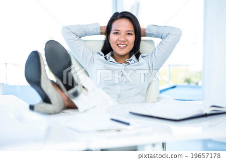 Smiling businesswoman relaxing herself Smiling businesswoman relaxing herself 19657178