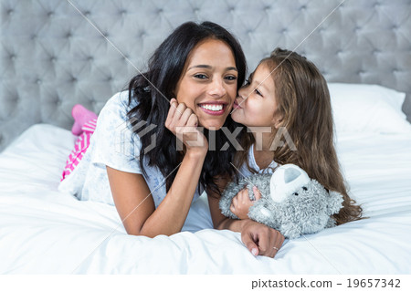 Happy mother and daughter laying o the bed Happy mother and daughter laying o the bed 19657342