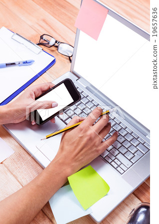Feminine hands holding smartphone and pencil 19657636