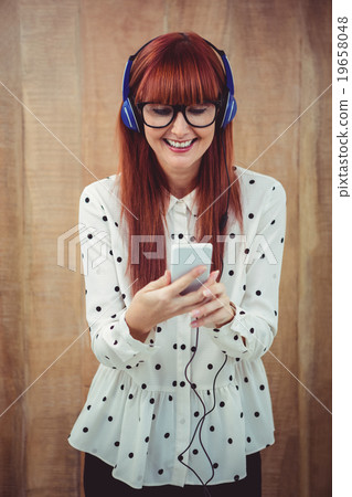 Attractive hipster woman listening to music with headphones Attractive hipster woman listening to music with headphones 19658048