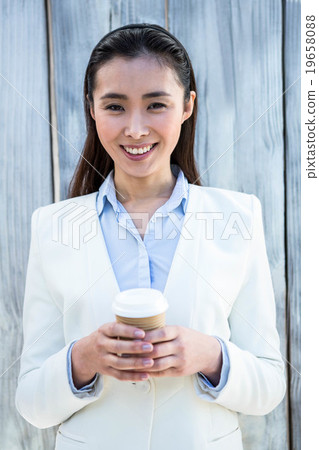 Smiling businesswoman with take-away coffee 19658088