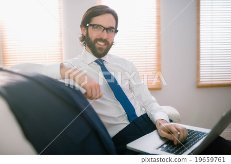 Businessman using laptop on the couch Businessman using laptop on the couch 19659761
