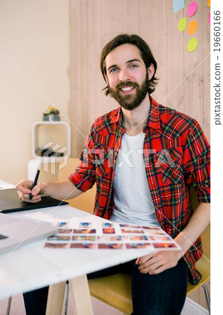 Handsome designer working at his desk Handsome designer working at his desk 19660166