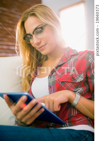 Pretty blonde using tablet on couch 19660373