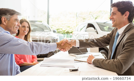 Smiling couple buying a new car Smiling couple buying a new car 19660734