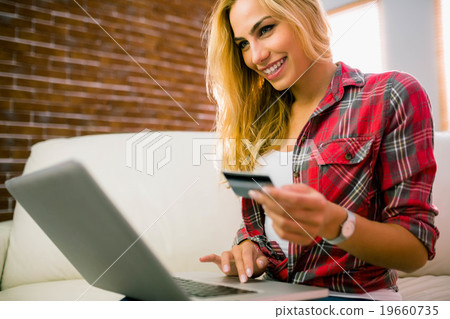 Pretty blonde using laptop on couch Pretty blonde using laptop on couch 19660735