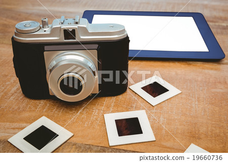 View of an old camera and a blue tablet View of an old camera and a blue tablet 19660736