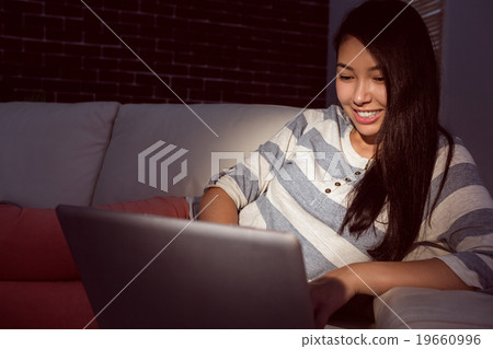 Asian woman using laptop at night 19660996